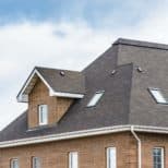 Chimney on the house against a blue sky - Big Easy Roofing Company