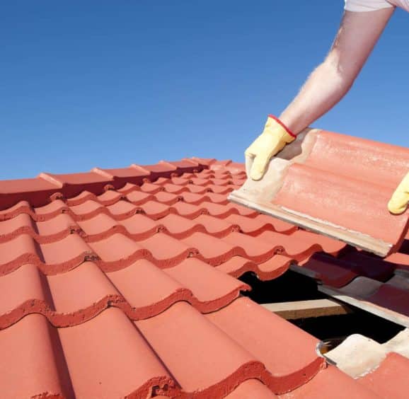 Construction worker tile roofing repair